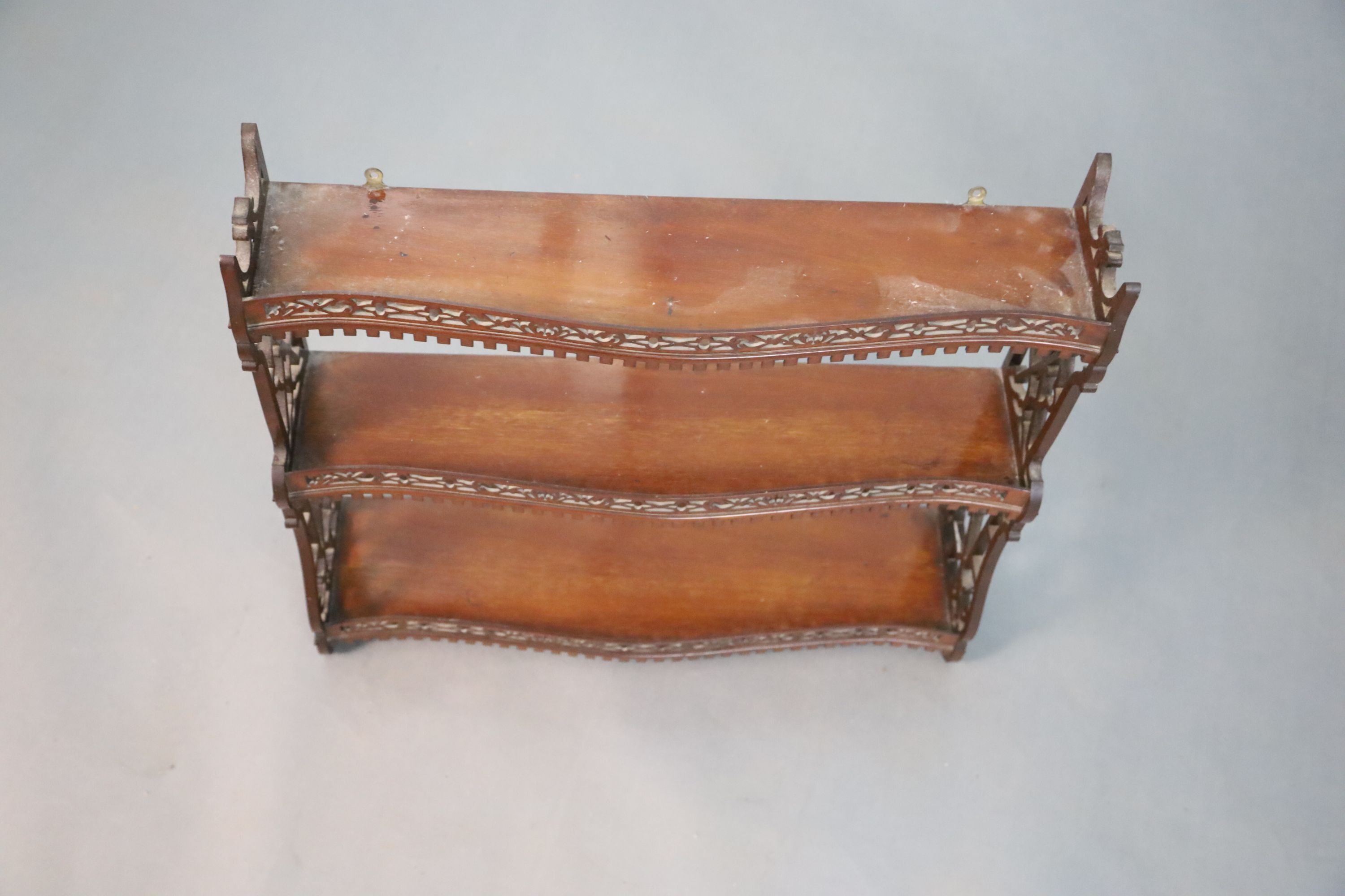 A George II style mahogany three tier wall shelf, W.66cm H.60.5cm